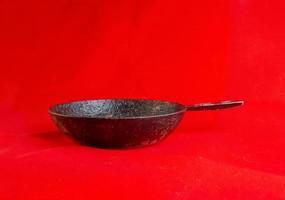 An old cast iron skillet made in circa 1960 against a red background. photo