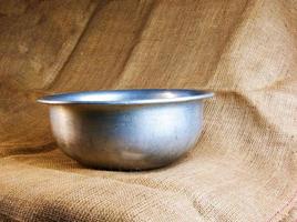 An old aluminum bowl made in circa 1960 with a burlap background. photo