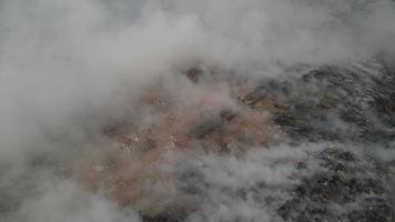 Aerial view burning and smoke at landfill site