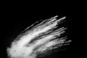 White powder explosion clouds.Freeze motion of white dust particles splash on black background. photo