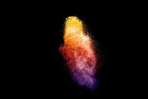 Colorful dust particles textured background.Multicolored powder explosion on black background. photo