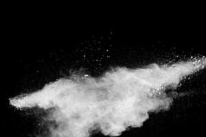 White powder explosion clouds.Freeze motion of white dust particles splash on black background. photo