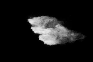 White powder explosion cloud against black background. White dust particles splash. photo