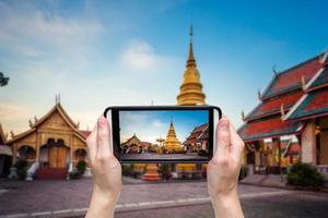 Hand taking photo at Wat phra that hariphunchai was a measure of the Lamphun,ThailandWat phra that hariphunchai was a measure of the Lamphun,Thailand