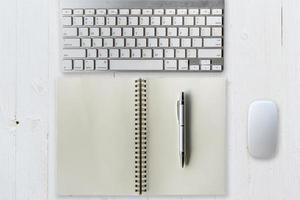 Office table with computer, supplies and notebook. View from above photo