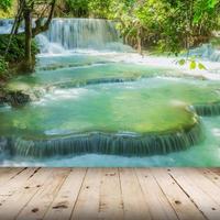 madera piso y cascada en lluvia bosque hacer encaje Kuang si cascadas a luang prabang, Laos. foto