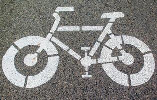 White arrows and bicycle sign path on the road photo