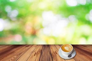 Coffee on table with bokeh background in garden photo