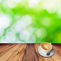 Coffee on table with bokeh background in garden photo