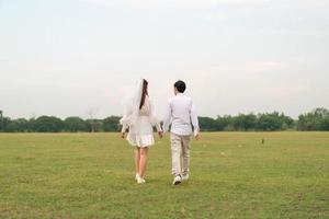 Happy young Asian couple in bride and groom clothing photo