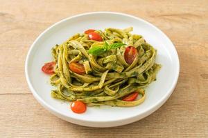 fettuccine spaghetti pasta with pesto sauce and tomatoes photo