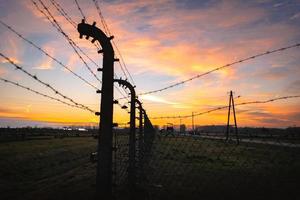 Memorial and museum Aushwitz-Birkenau, former Auschwitz Nazi death camp in Oswiecim, Poland. Barracks and elecrified fencing. photo