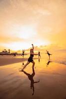 a group of Asian women in black clothes playing with their friends on the beach photo