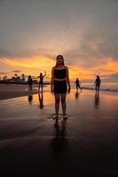 portrait of an Asian woman in black clothes standing on the beach with a very sad expression photo