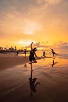 a group of Asian women in black clothes playing with their friends on the beach photo