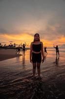 portrait of an Asian woman in black clothes standing on the beach with a very sad expression photo