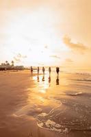 a group of Asian teenagers running with happy expressions on vacation with their friends drunk on the beach photo