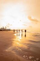 un grupo de asiático adolescentes corriendo con contento expresiones en vacaciones con su amigos borracho en el playa foto