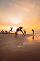 a group of Indonesian women doing ballet movement exercises together very flexibly on the beach photo