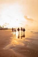 un grupo de asiático adolescentes corriendo con contento expresiones en vacaciones con su amigos borracho en el playa foto