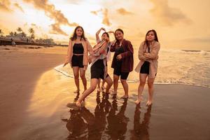 un grupo de asiático mujer disfrutando su fiesta muy loco con su amigos y con un lleno expresión de tontería en el playa foto