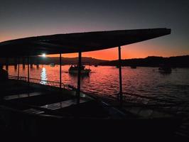 asombroso ver de silueta de un barco y puesta de sol foto