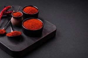 Spice smoked paprika in the form of powder in bowls and spoons photo