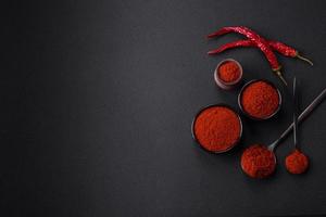 Spice smoked paprika in the form of powder in bowls and spoons photo