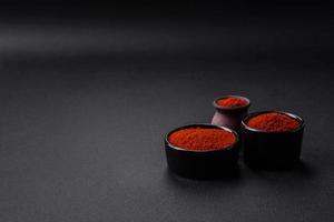 Spice smoked paprika in the form of powder in bowls and spoons photo