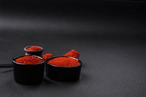 Spice smoked paprika in the form of powder in bowls and spoons photo