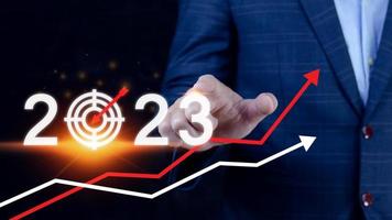 Business target and goal 2023 icon, hand pointing holding 2023 virtual screen and up arrow, Start new year 2023 with a goal plan, action plan, strategy, new year business vision. photo