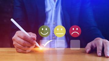 Businessman choosing happy smile face icon. feedback rating and positive customer review experience, satisfaction survey. mental health assessment. World mental health day concept photo