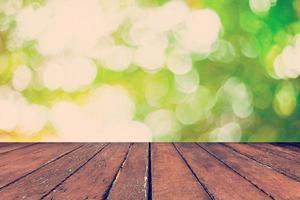 abstract blurred green bokeh and wood table background with space. photo