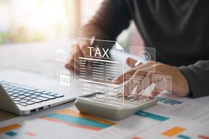 Corporate and individual tax payment concept, businessman using computer filling out corporate and personal income tax return, VAT and property tax of business. photo