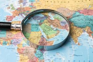 Bangkok, Thailand - January 20, 2022 Asia, Magnifying glass close up with colorful world map, travel, geography, tourism and exploration concept. photo
