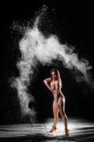 Young slim woman with spread flour on the air photo