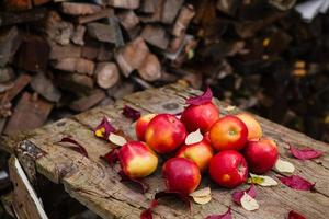 Still life with several red apples lying on an old wooden table photo