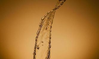 Falling water on a golden background photo