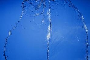 Falling water on a blue background photo