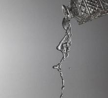 Falling water on a silver background photo