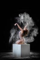 Young slim woman with spread flour on the air photo