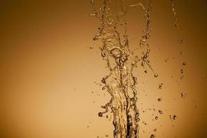 Falling water on a golden background photo