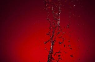 Falling water on a red background photo