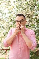 man using nasal spray while walking in the park photo