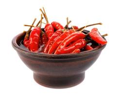 Clay cup with pickled chili peppers isolated on white background. Full clipping path. photo