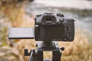 Open back of camera filming water with yellow reeds and garass landscape with visible menu on the screen photo