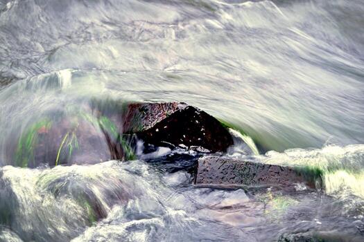 Water flowing over rocks long exposure of river flow with green water grass photo