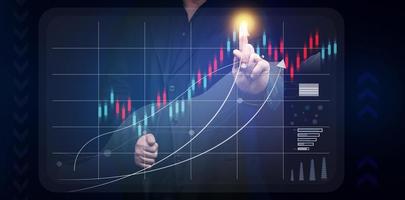 man in a black shirt stands in front of a holographic graph with growing indicators. Business growth, sales increase. High performance photo