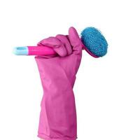 hand in a pink rubber glove for cleaning a house holds plastic brush with a handle photo