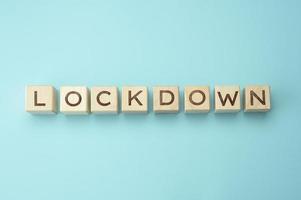 wooden blocks with the inscription lockdown on a blue background. Self-isolation concept to prevent the spread of viruses in settlements photo